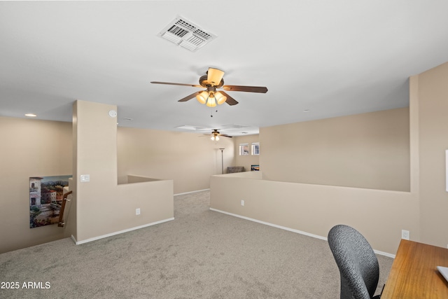 carpeted office space with baseboards, visible vents, and a ceiling fan