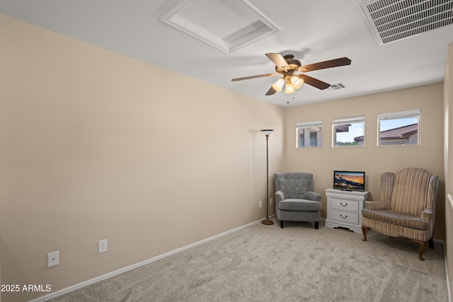 living area with light carpet, baseboards, visible vents, and attic access