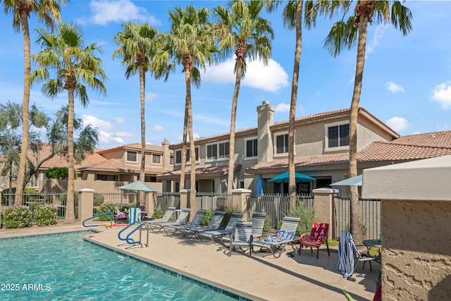 pool with a patio and fence