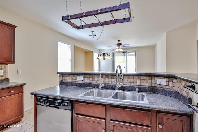 kitchen with stainless steel dishwasher, light tile patterned floors, dark countertops, backsplash, and a sink