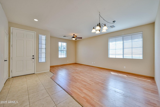 entrance foyer featuring light tile patterned floors, visible vents, baseboards, recessed lighting, and ceiling fan with notable chandelier