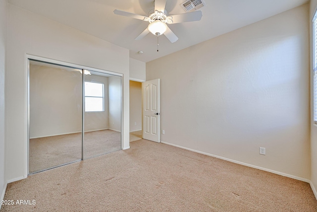 unfurnished bedroom featuring visible vents, ceiling fan, a closet, baseboards, and carpet floors