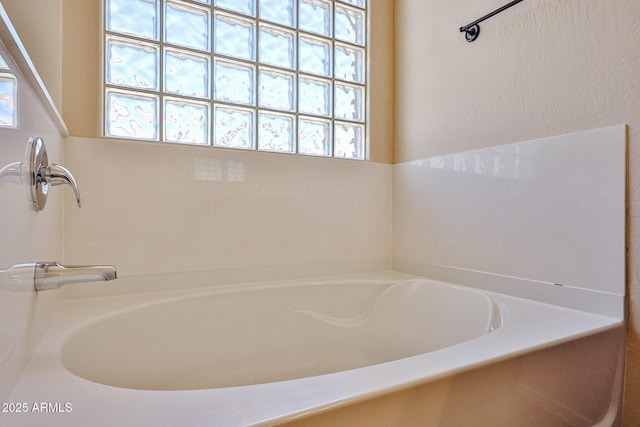 bathroom featuring a bath and a wealth of natural light
