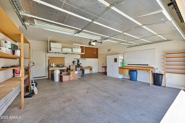 garage with a workshop area and a garage door opener