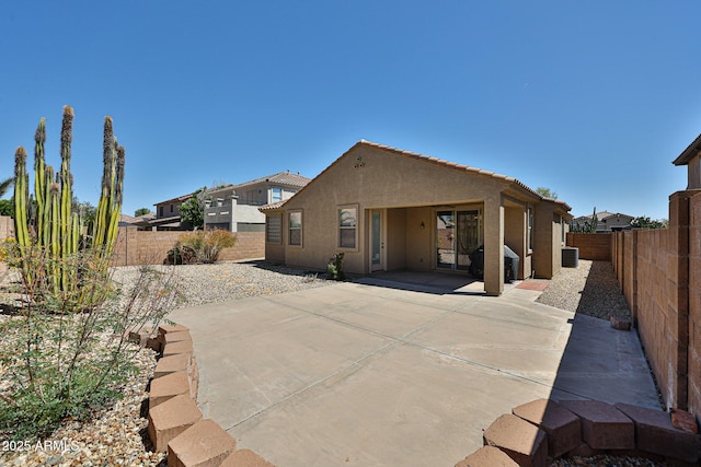 rear view of house with a patio, a fenced backyard, and stucco siding