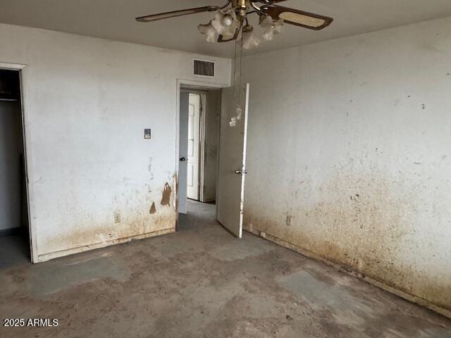 unfurnished bedroom with ceiling fan, concrete flooring, and a closet