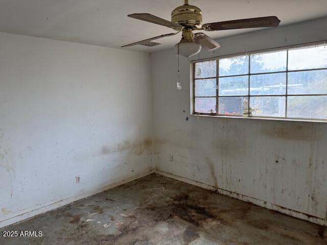 empty room with concrete floors and ceiling fan