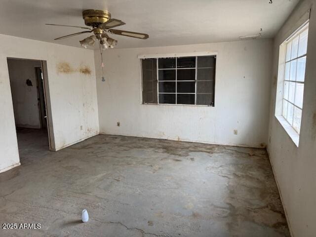 spare room featuring concrete floors and ceiling fan