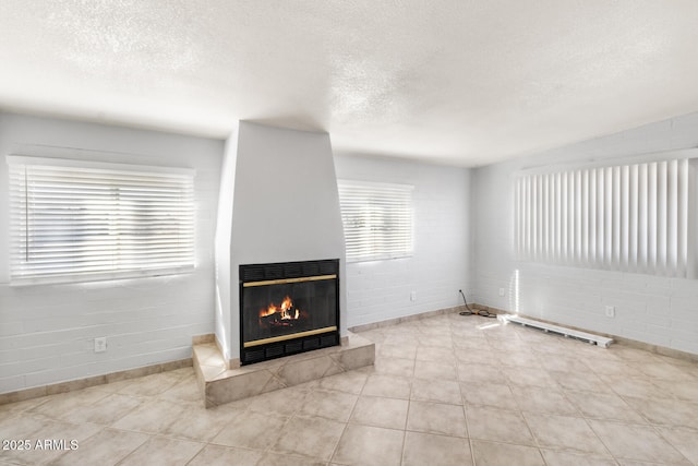 unfurnished living room featuring lofted ceiling, a textured ceiling, and light tile patterned floors