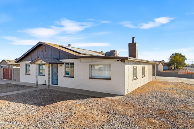 rear view of property with solar panels and central AC unit