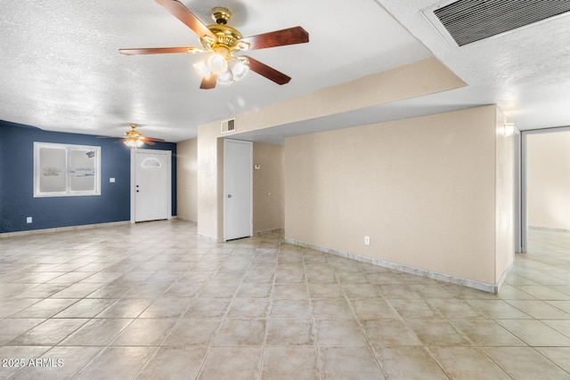 spare room featuring a textured ceiling, light tile patterned flooring, and ceiling fan