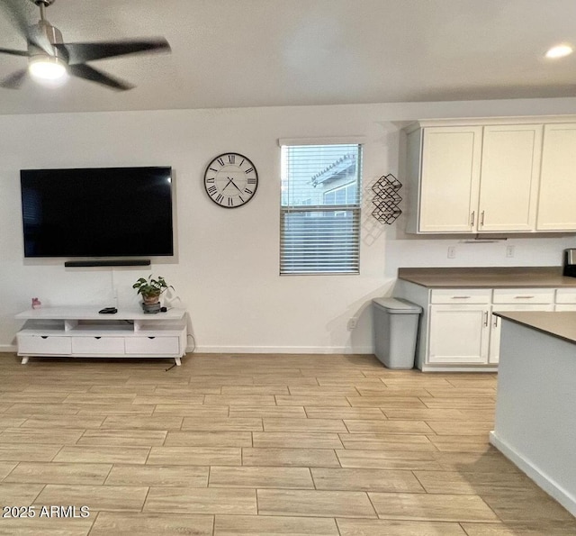 kitchen featuring ceiling fan, baseboards, and wood finish floors