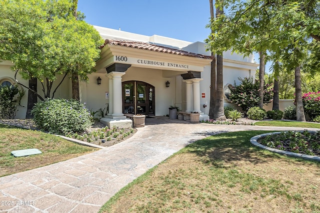 mediterranean / spanish home with a front yard and french doors