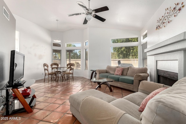 living room featuring ceiling fan, a wealth of natural light, tile patterned flooring, and a tile fireplace