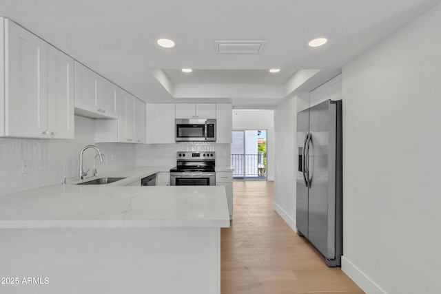 220 N 22nd Pl Unit 2036, Mesa, AZ 85213 - kitchen featuring appliances with stainless steel finishes, light countertops, decorative backsplash, a peninsula, and white cabinetry