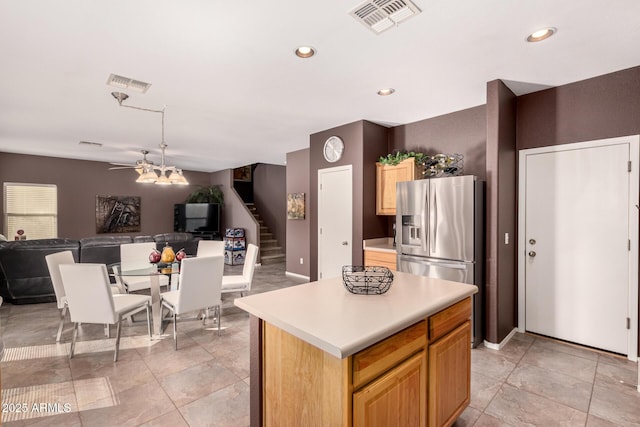 kitchen featuring ceiling fan, stainless steel fridge, and a kitchen island