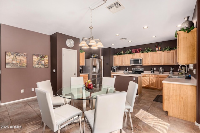 dining space featuring an inviting chandelier, tile patterned flooring, and sink