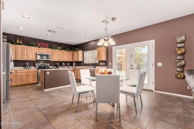 dining space with sink, french doors, and an inviting chandelier