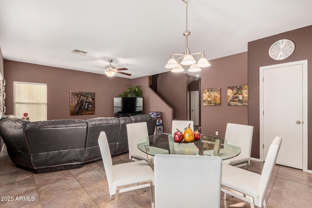 dining room with ceiling fan with notable chandelier