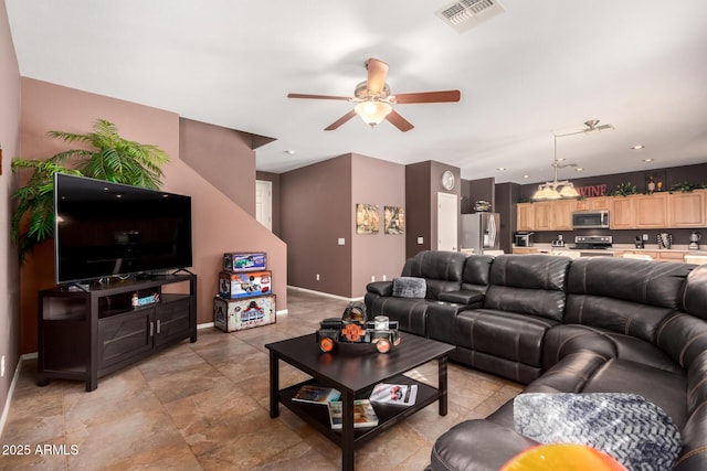 living room with ceiling fan with notable chandelier