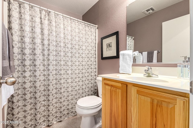 bathroom with toilet, vanity, and a textured ceiling