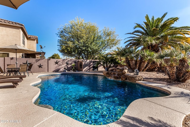 view of pool with pool water feature and a patio