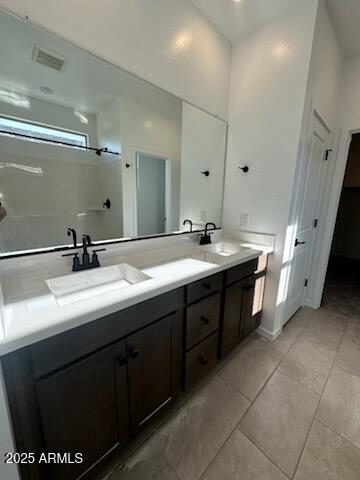 bathroom featuring tile patterned floors, vanity, and a shower