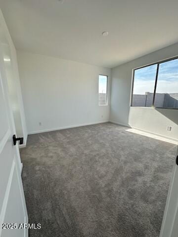 spare room featuring dark colored carpet