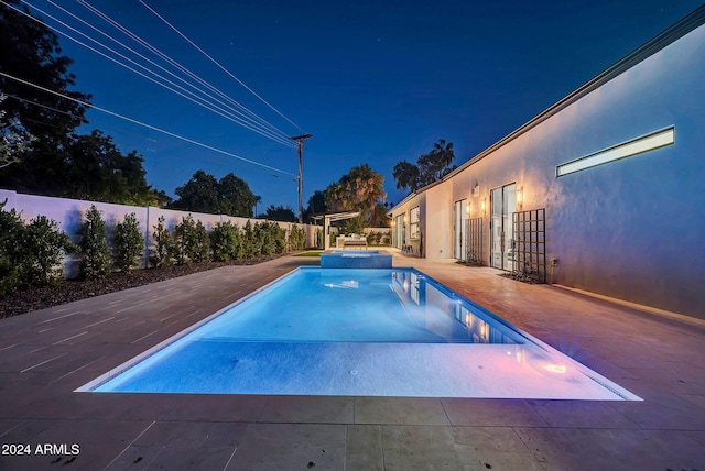 view of swimming pool featuring a patio area, a fenced backyard, and a pool with connected hot tub