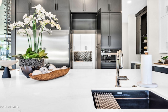 kitchen with tasteful backsplash, light countertops, and a sink