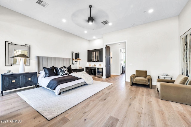 bedroom with connected bathroom, light wood-type flooring, and ceiling fan