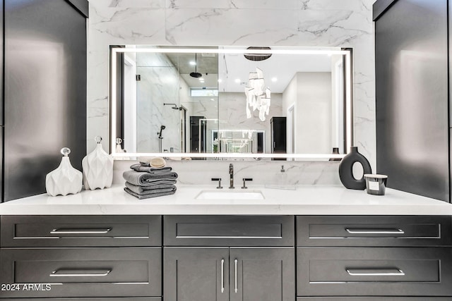 full bath with a marble finish shower and vanity