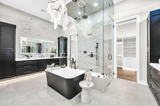 full bath with tile patterned flooring, visible vents, vanity, a soaking tub, and a marble finish shower