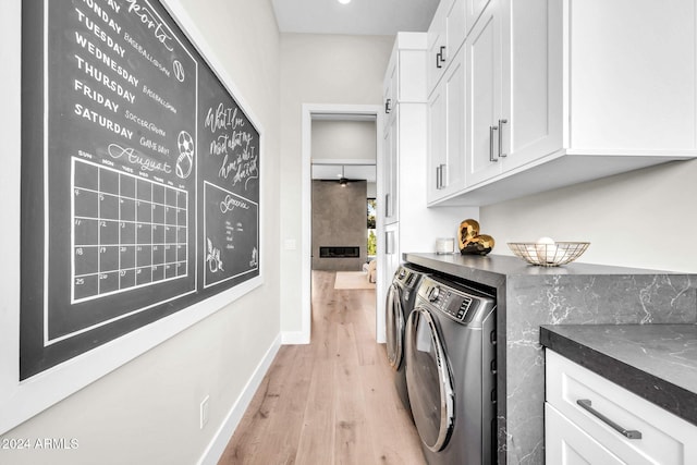 laundry area featuring baseboards, light wood-style floors, and washer and dryer