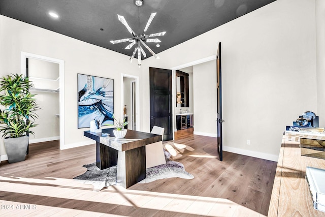 office with baseboards, wood finished floors, and an inviting chandelier