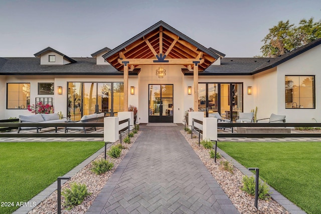 rear view of property featuring stucco siding, outdoor lounge area, a yard, and a patio