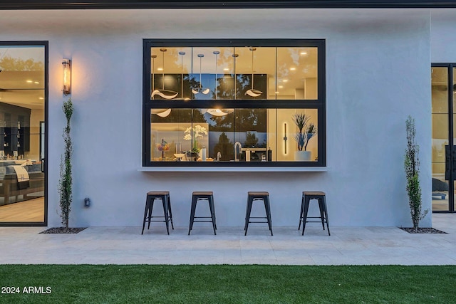 exterior space featuring outdoor dry bar, a patio area, and stucco siding