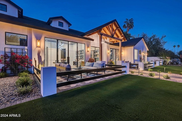 rear view of property featuring outdoor lounge area and a yard