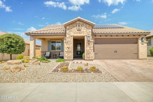 view of front of house with an attached garage, stone siding, a tiled roof, decorative driveway, and stucco siding