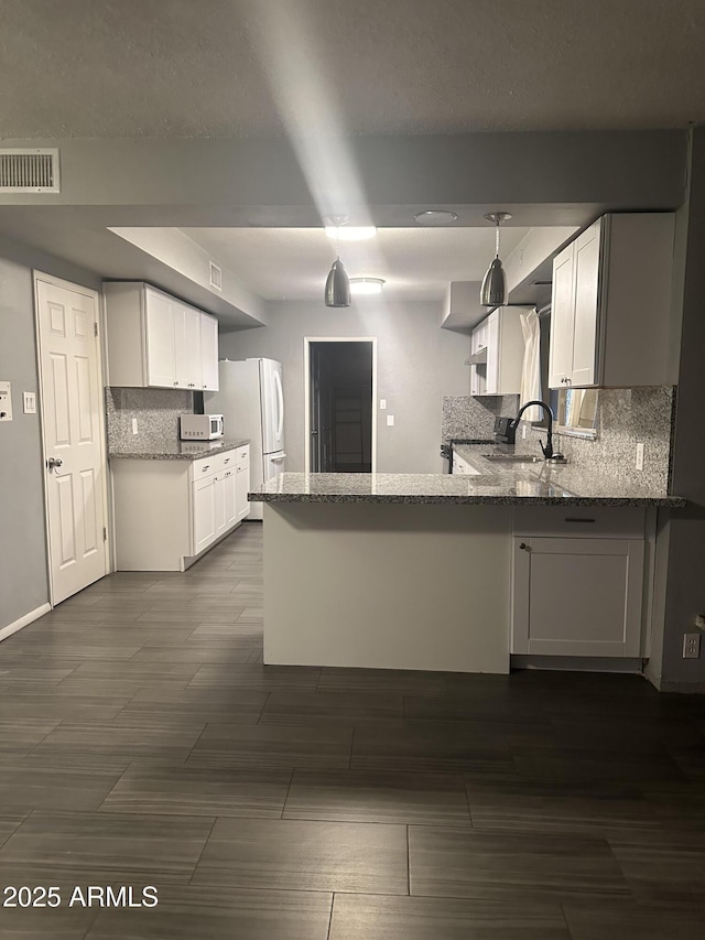 kitchen featuring white cabinetry, light stone counters, and white appliances