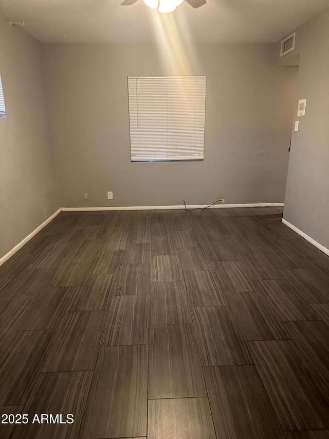 unfurnished room featuring dark wood-type flooring and ceiling fan