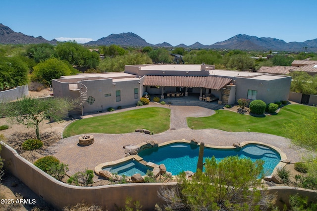 back of house with a mountain view, a patio, a fenced backyard, and a tiled roof