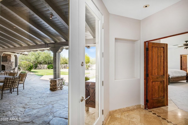 exterior space featuring stone tile floors and baseboards