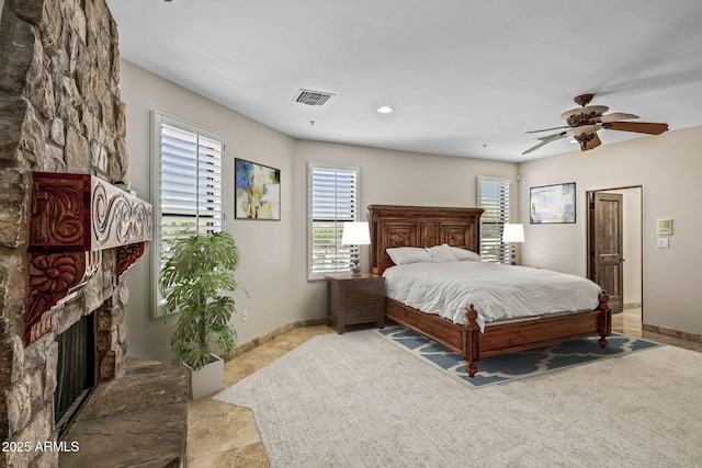 carpeted bedroom with baseboards, multiple windows, and a stone fireplace