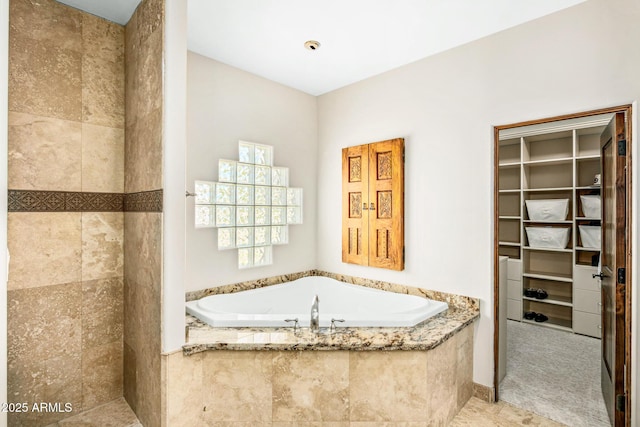 bathroom with a bath and a spacious closet