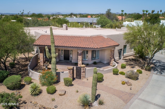 mediterranean / spanish home featuring a gate, stucco siding, a chimney, a fenced front yard, and a tiled roof