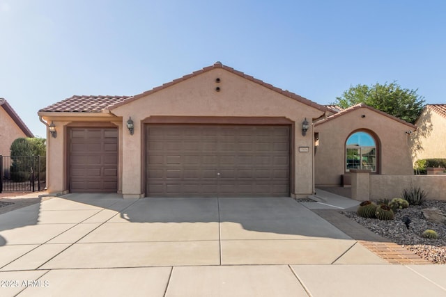 7504 W Patriot Way, Florence, AZ 85132 - mediterranean / spanish-style house with an attached garage, concrete driveway, stucco siding, and a tiled roof