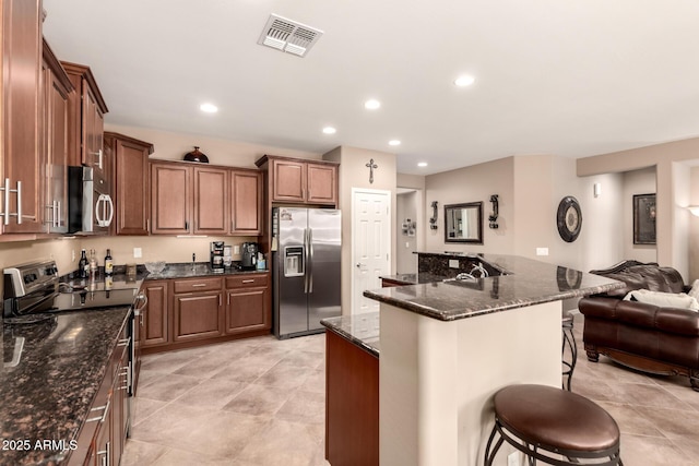 7504 W Patriot Way, Florence, AZ 85132 - kitchen with appliances with stainless steel finishes, a breakfast bar, open floor plan, recessed lighting, and a kitchen island
