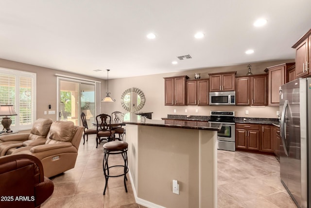 7504 W Patriot Way, Florence, AZ 85132 - kitchen with stainless steel appliances, open floor plan, a kitchen breakfast bar, recessed lighting, and a kitchen island