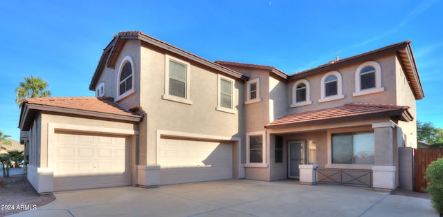 view of front of house with driveway, an attached garage, a tiled roof, and stucco siding